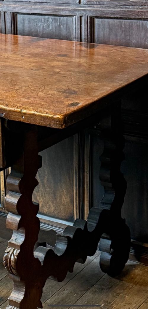 A 17th-century dark walnut side table featuring a geometrically carved single drawer, detailed trestle end supports, and a shaped central stretcher. View VIII