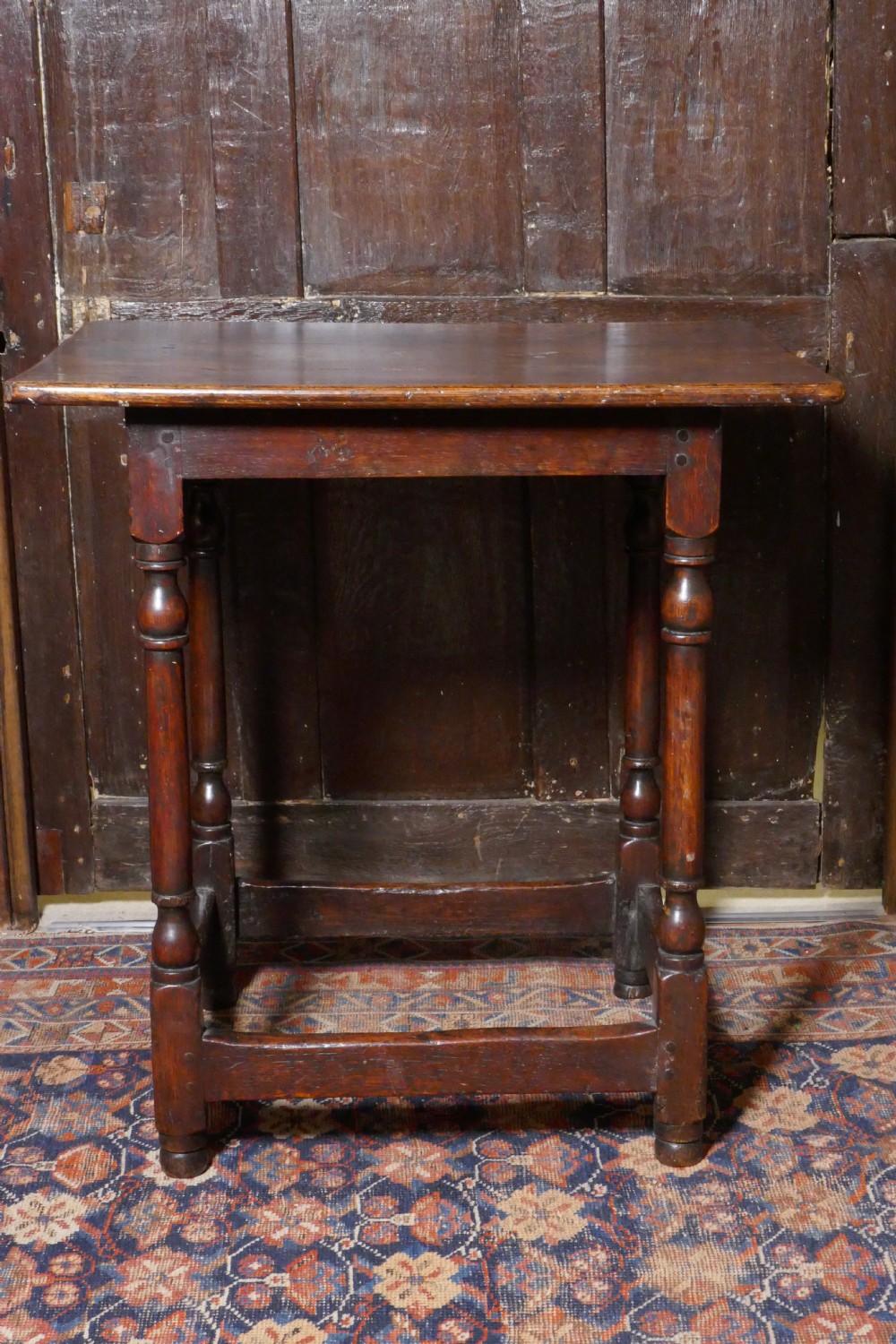 A 17th-century dark oak side table featuring a rectangular plank top, turned legs, and square perimeter stretchers. View IV