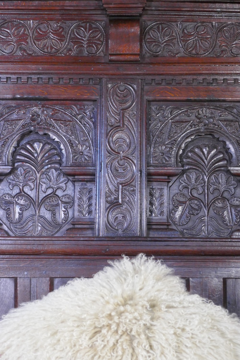 A dark oak 17th-century full tester bed featuring a relief-carved headboard, turned front posts, and a coffered ceiling canopy. View IV