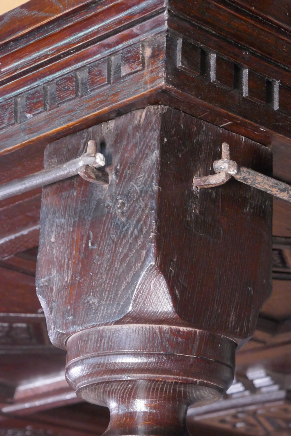 A dark oak 17th-century full tester bed featuring a relief-carved headboard, turned front posts, and a coffered ceiling canopy. View XIII