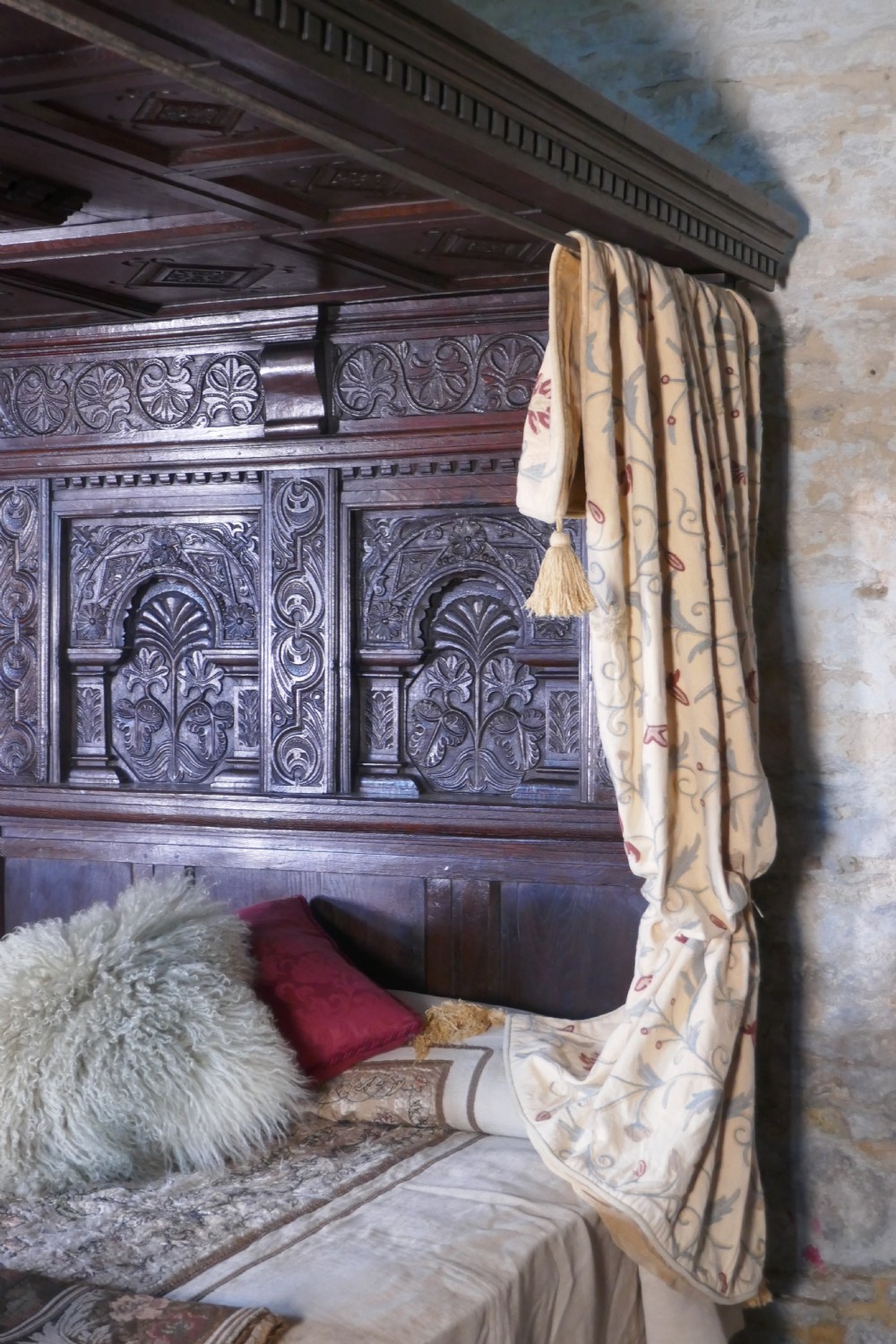 A dark oak 17th-century full tester bed featuring a relief-carved headboard, turned front posts, and a coffered ceiling canopy. View XIV