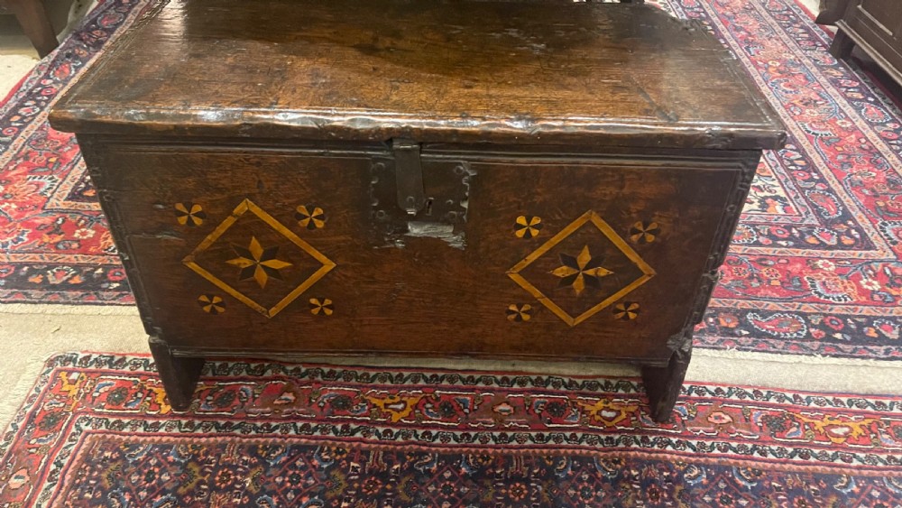 A dark oak 16th-century coffer featuring geometric star marquetry inlay within diamond panels and a hand-forged iron lockplate. View II