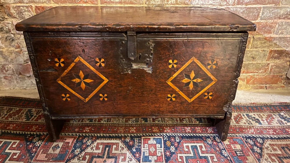A dark oak 16th-century coffer featuring geometric star marquetry inlay within diamond panels and a hand-forged iron lockplate. View XXIII