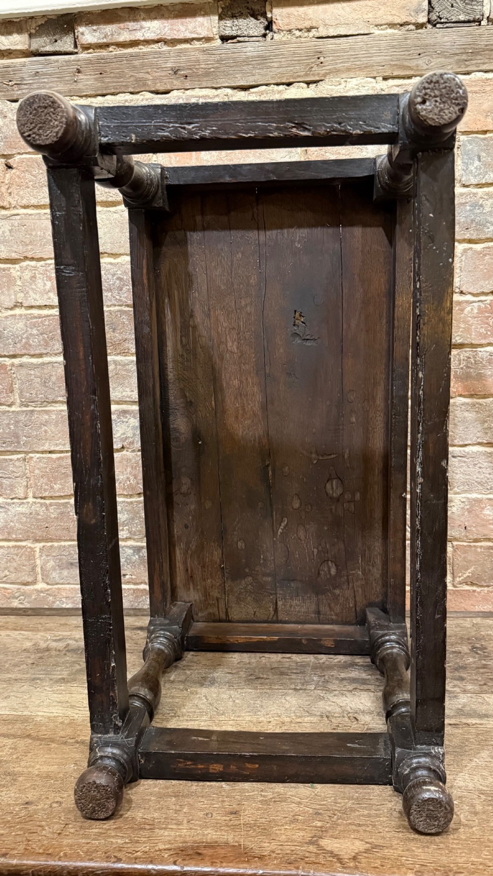 A dark oak 17th-century joint stool featuring a carved arcaded apron, turned legs, and lower box stretchers. View XXI