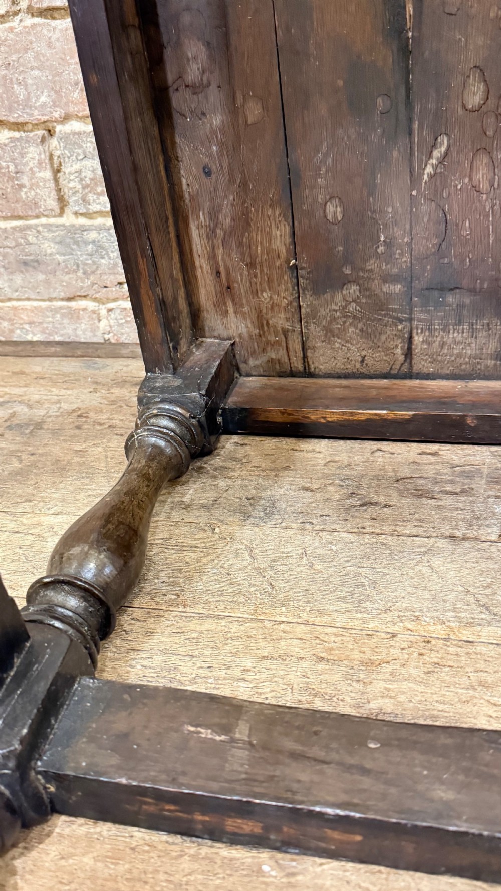 A dark oak 17th-century joint stool featuring a carved arcaded apron, turned legs, and lower box stretchers. View XXIV