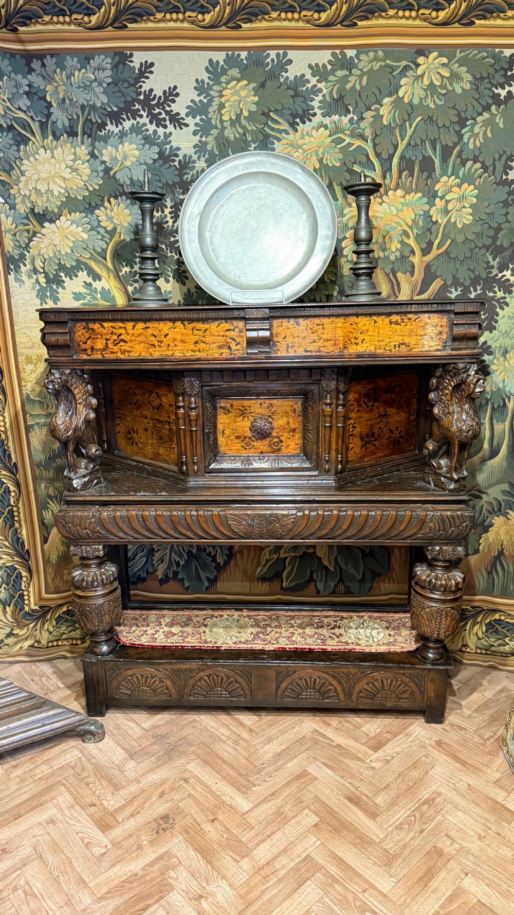 A 17th-century carved oak livery cupboard featuring inlaid wooden panels, carved lion supports, and bulbous turned legs. View II