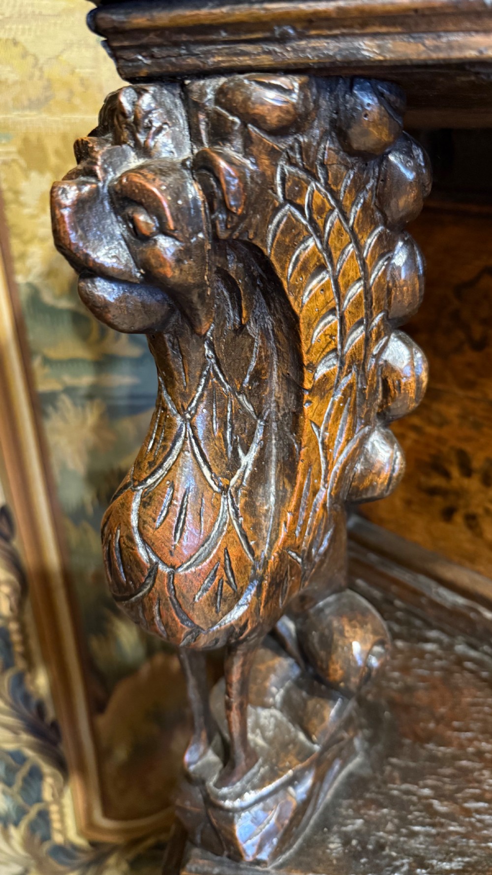 A 17th-century carved oak livery cupboard featuring inlaid wooden panels, carved lion supports, and bulbous turned legs. View IX