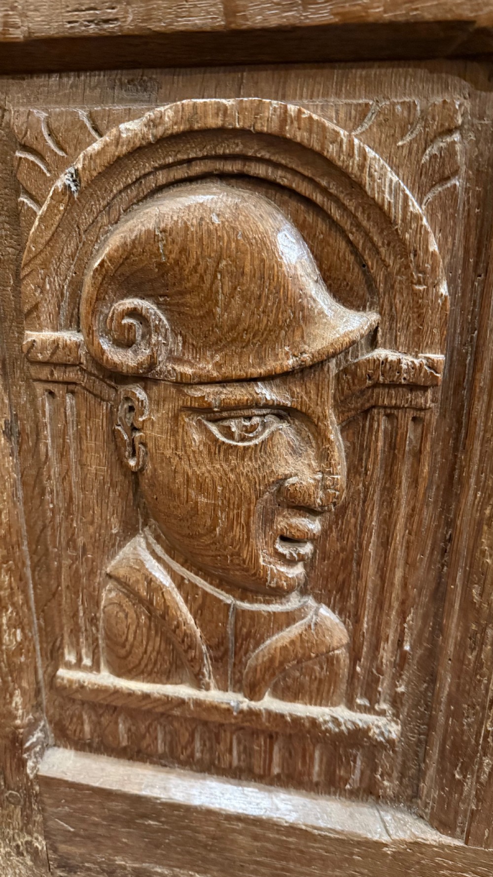 A 16th-century oak coffer featuring two carved Romayne head panels set within carved arches and a central keyhole escutcheon. View IV