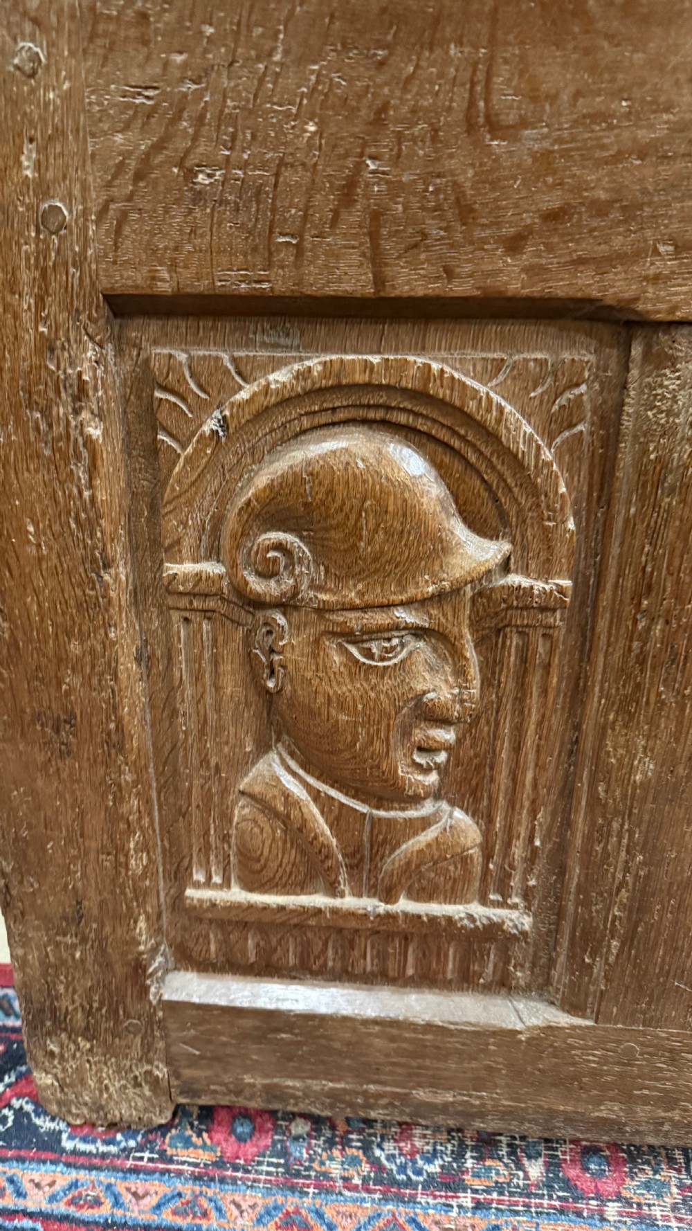 A 16th-century oak coffer featuring two carved Romayne head panels set within carved arches and a central keyhole escutcheon. View VI