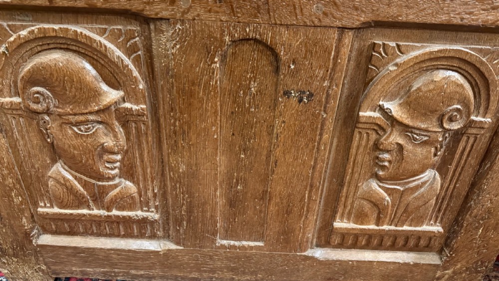 A 16th-century oak coffer featuring two carved Romayne head panels set within carved arches and a central keyhole escutcheon. View IX