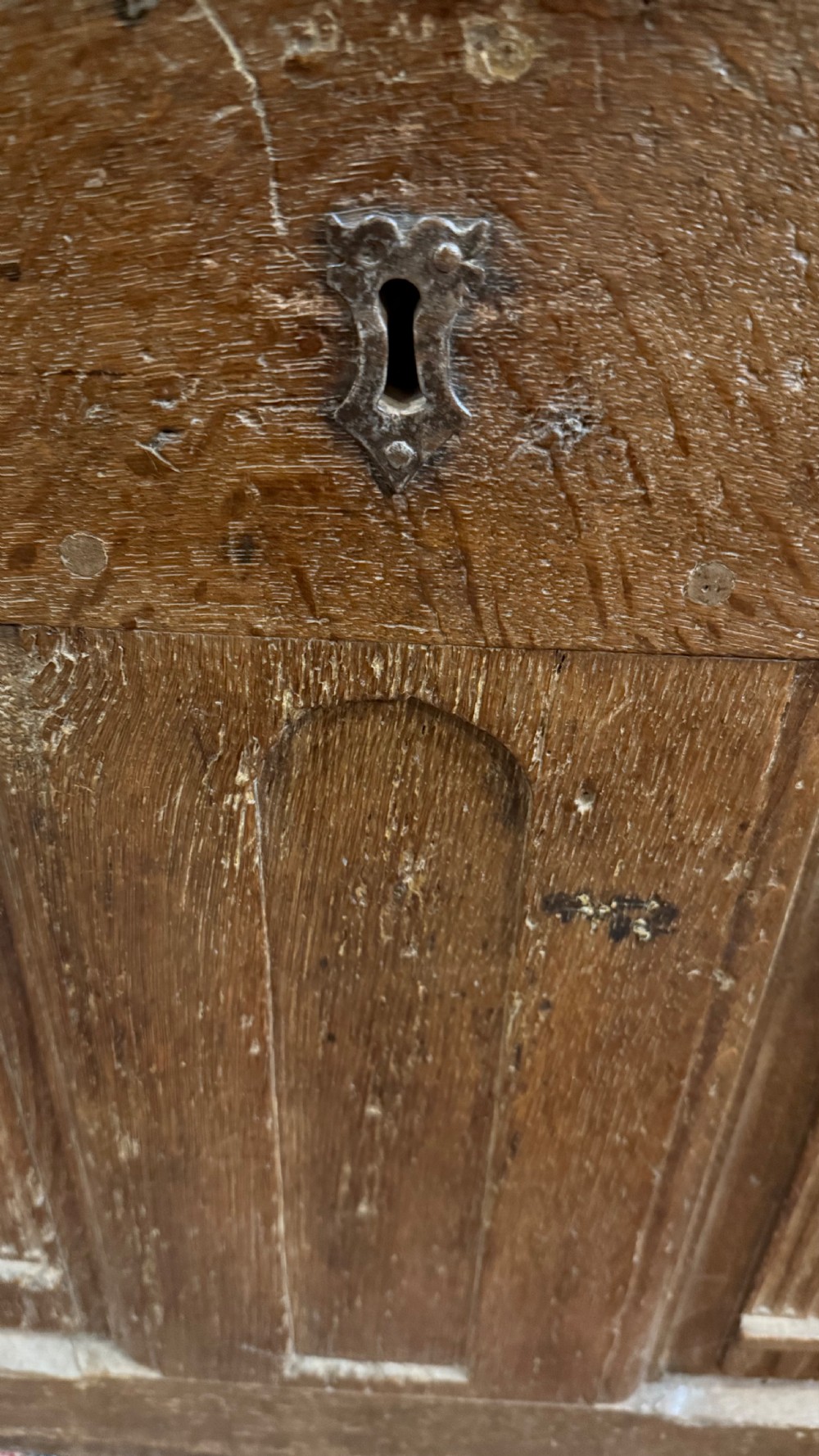 A 16th-century oak coffer featuring two carved Romayne head panels set within carved arches and a central keyhole escutcheon. View X