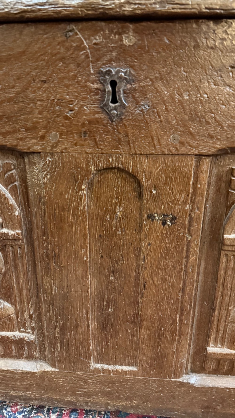 A 16th-century oak coffer featuring two carved Romayne head panels set within carved arches and a central keyhole escutcheon. View XI