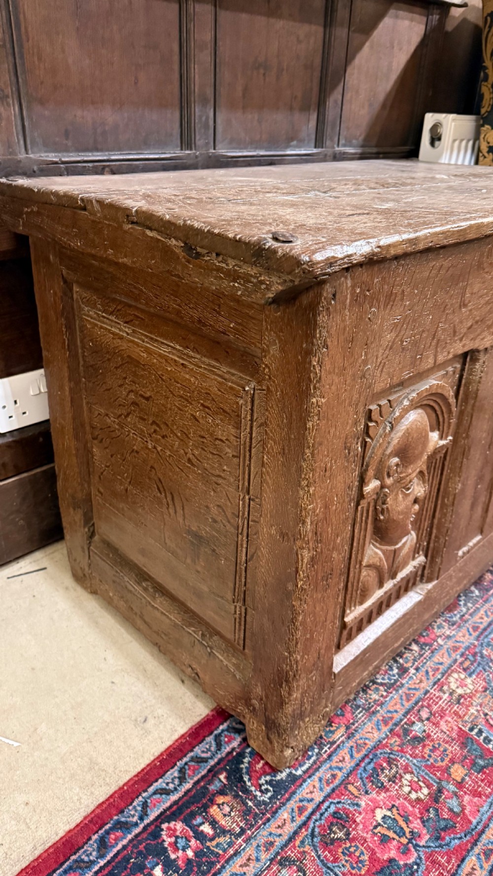 A 16th-century oak coffer featuring two carved Romayne head panels set within carved arches and a central keyhole escutcheon. View XIII