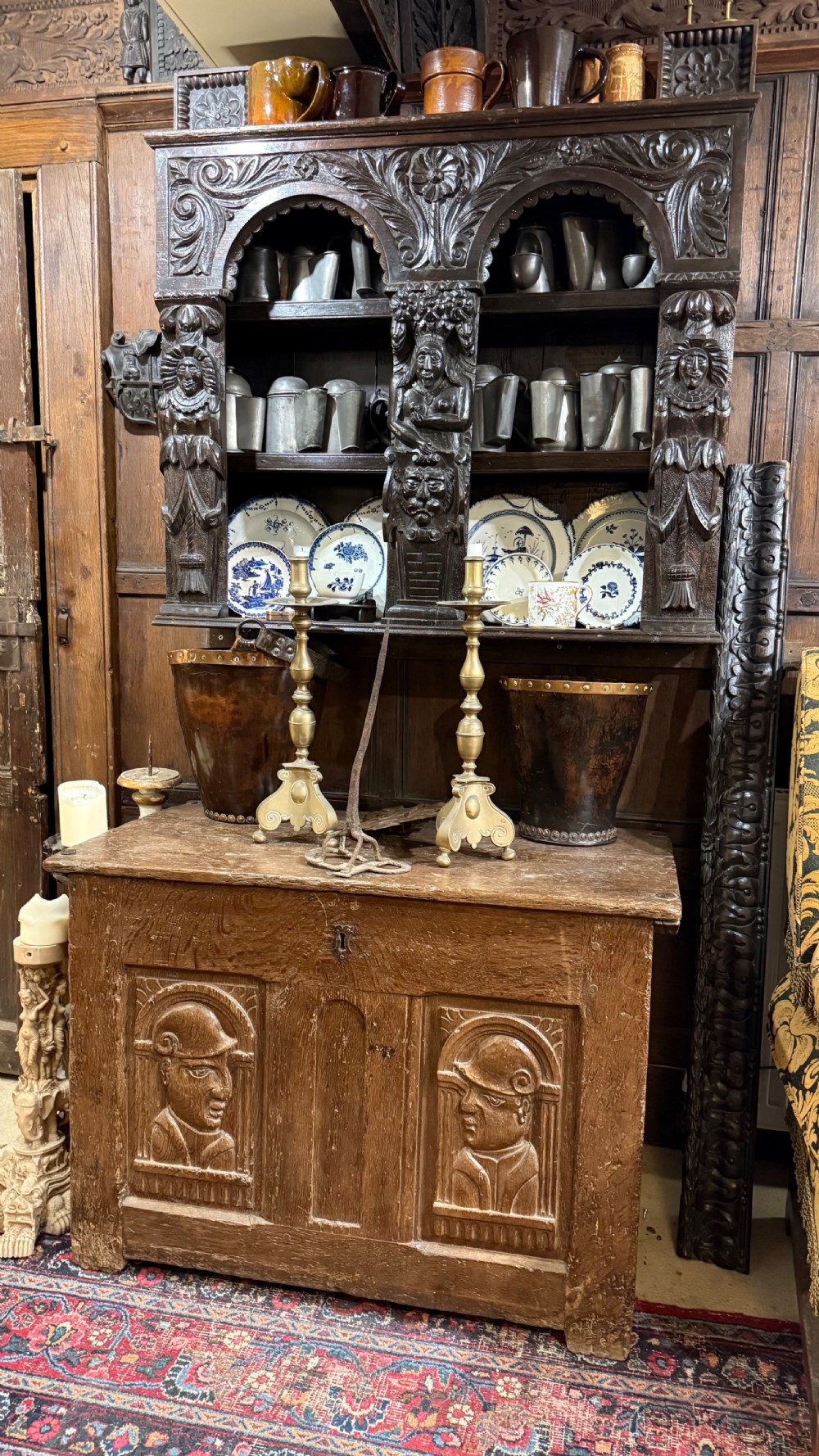 A 16th-century oak coffer featuring two carved Romayne head panels set within carved arches and a central keyhole escutcheon. View XXIV