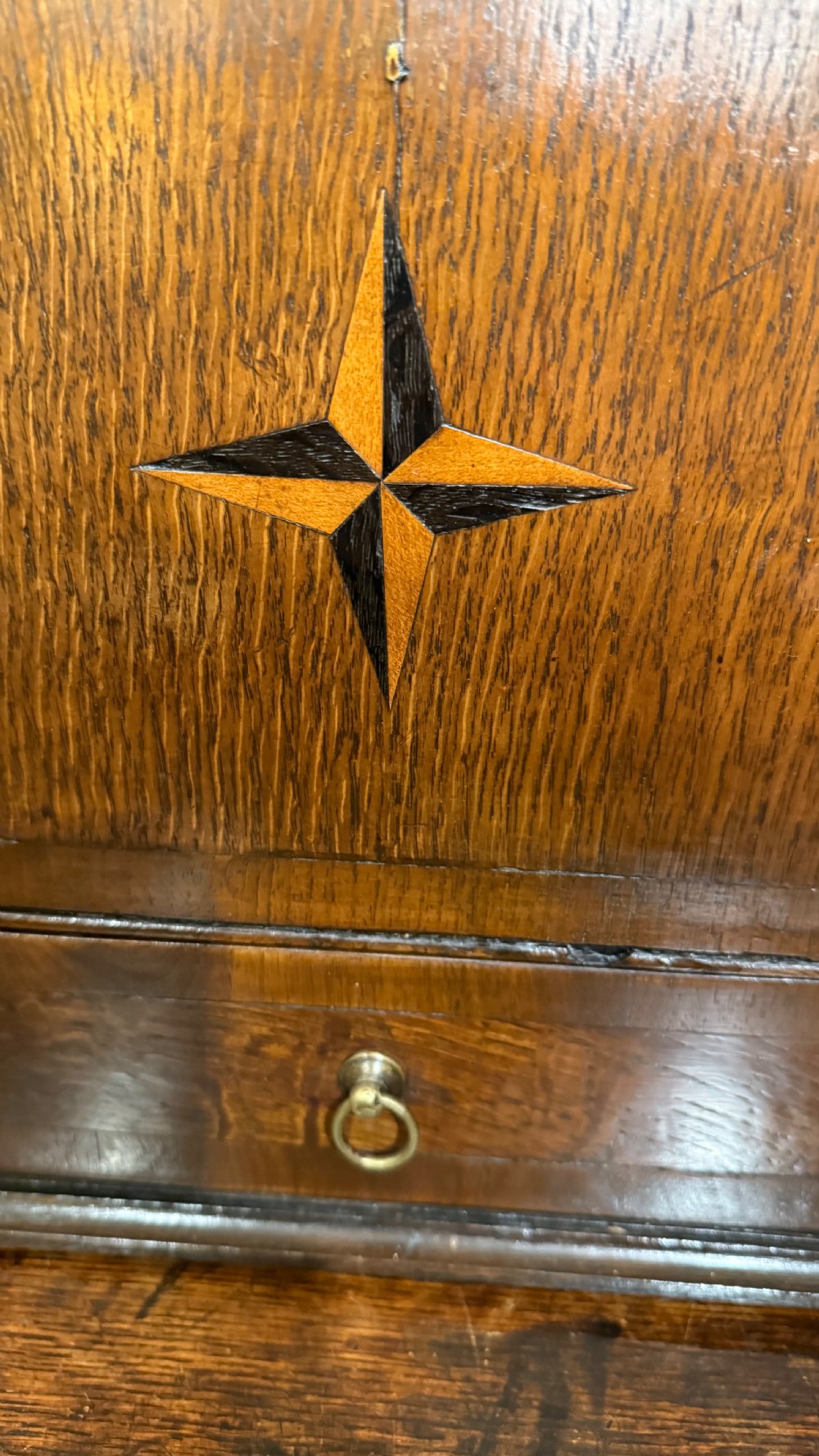 A 19th-century wall-mounted oak box featuring a star marquetry inlay, a heart-shaped hanging cut-out, and a lower drawer with a metal ring pull. View XII