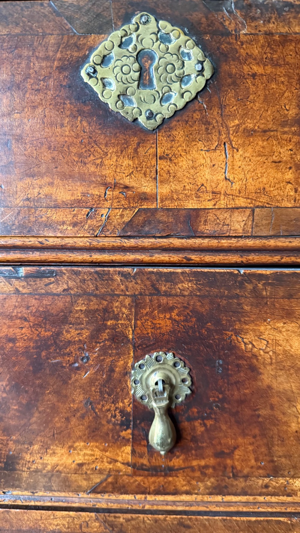 A late 17th-century walnut chest on stand featuring brass drop handles, five drawers, an arched apron, and six turned legs with shaped stretchers. View III