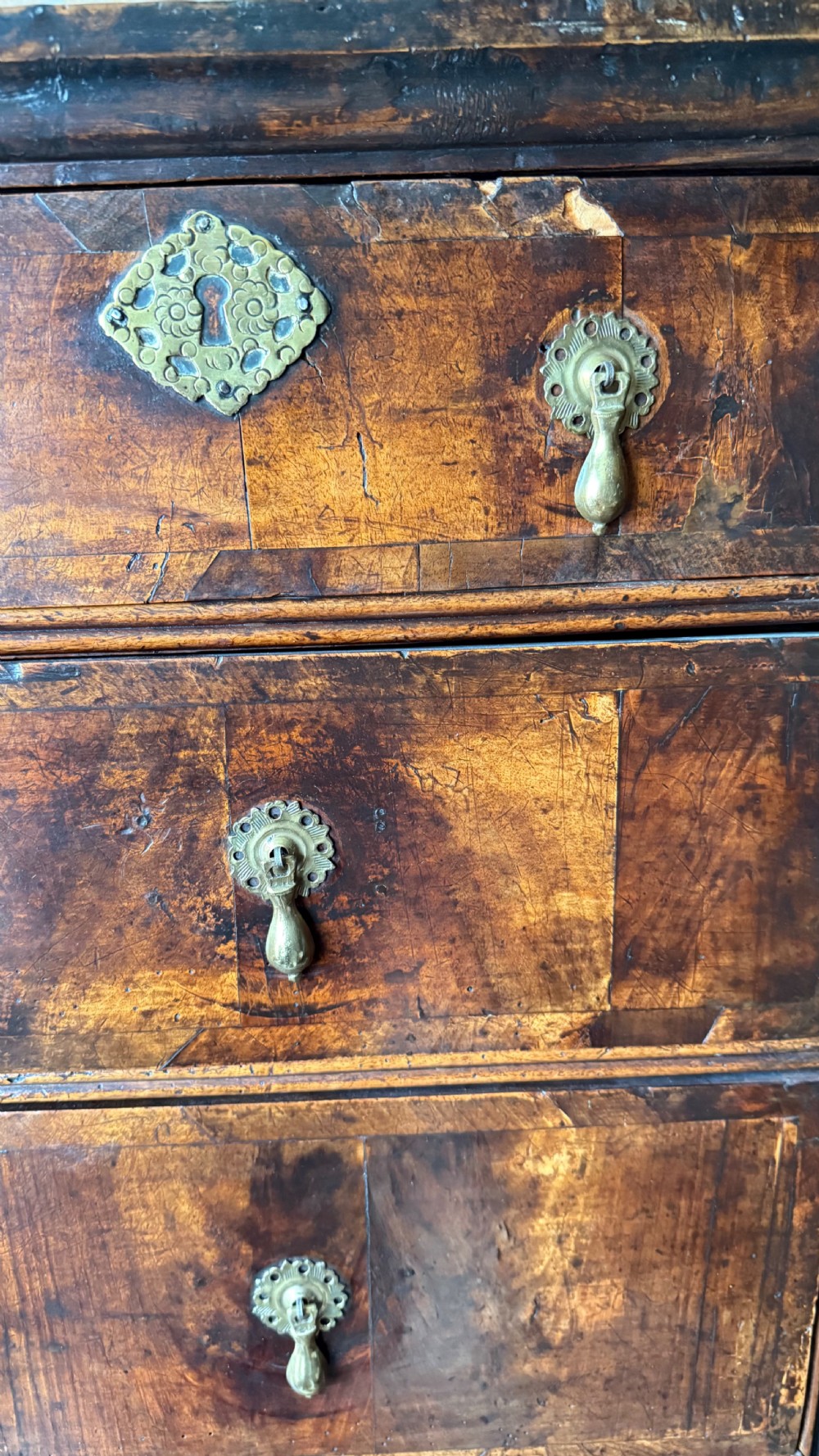 A late 17th-century walnut chest on stand featuring brass drop handles, five drawers, an arched apron, and six turned legs with shaped stretchers. View VII
