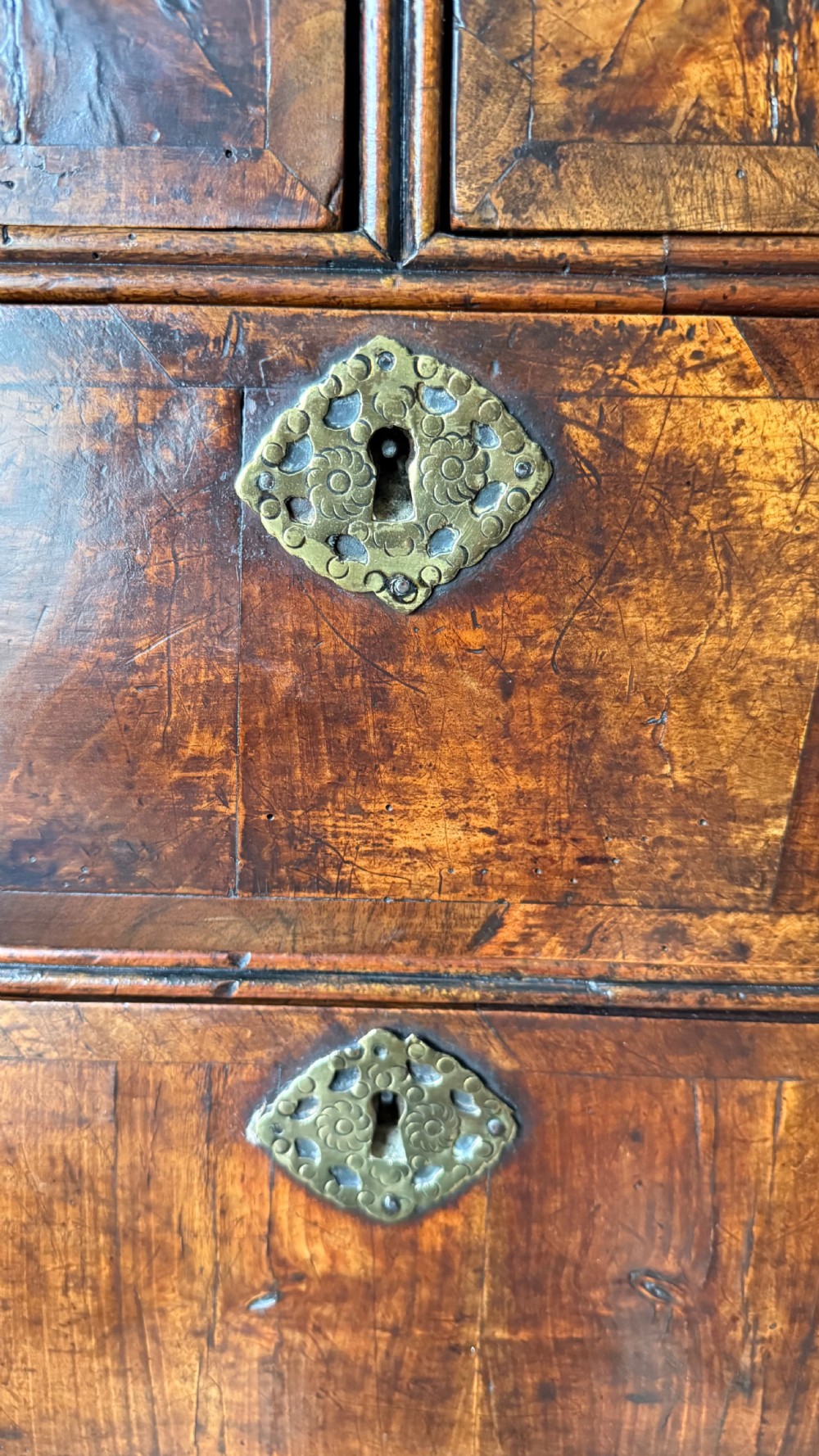 A late 17th-century walnut chest on stand featuring brass drop handles, five drawers, an arched apron, and six turned legs with shaped stretchers. View VIII