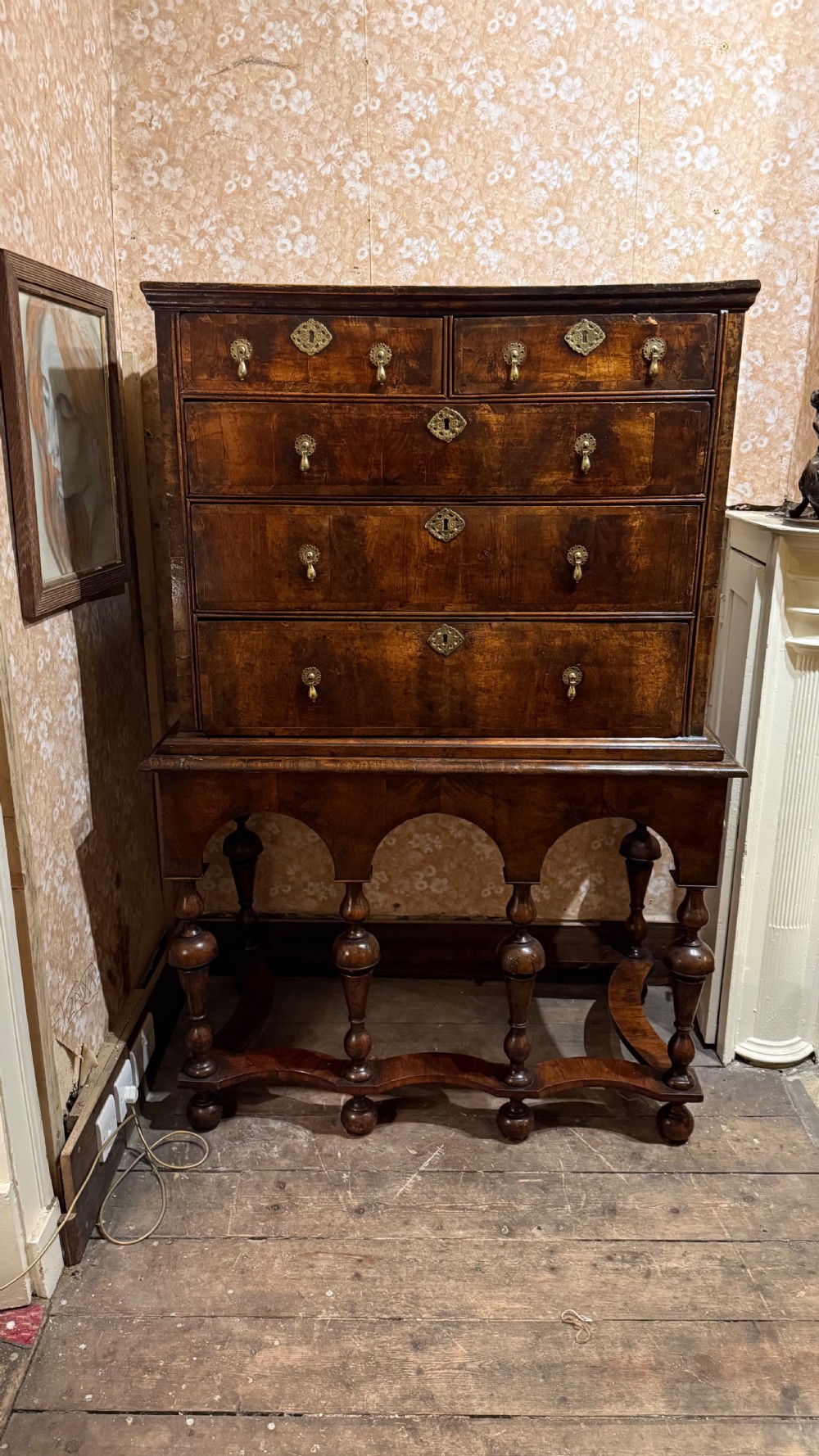 A late 17th-century walnut chest on stand featuring brass drop handles, five drawers, an arched apron, and six turned legs with shaped stretchers. View XIII