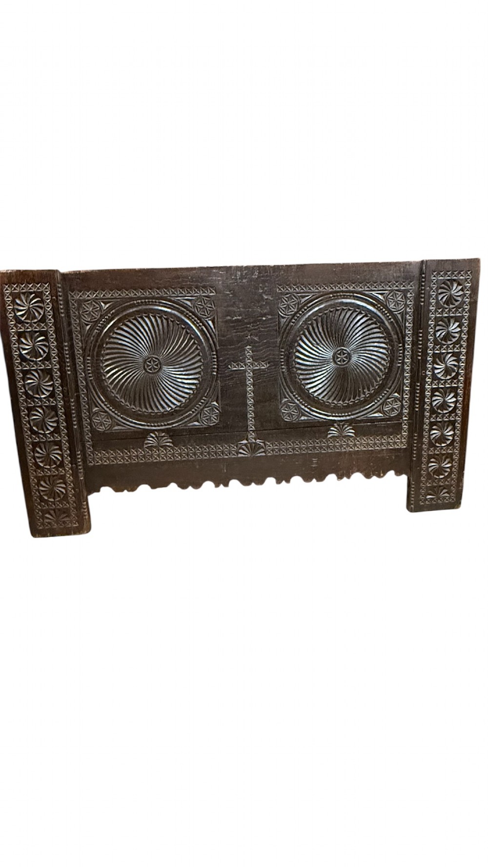 A 16th-century carved dark oak coffer front panel featuring central cross and circular pinwheel motifs with geometric borders. View II