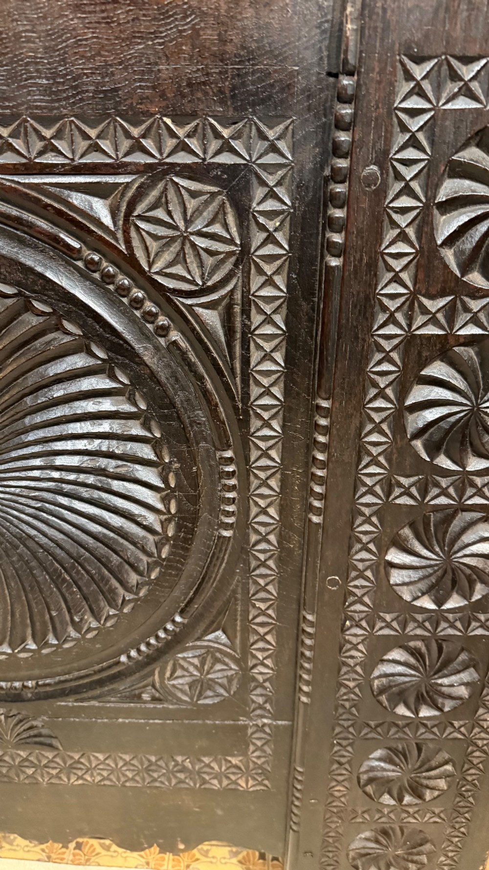 A 16th-century carved dark oak coffer front panel featuring central cross and circular pinwheel motifs with geometric borders. View VII