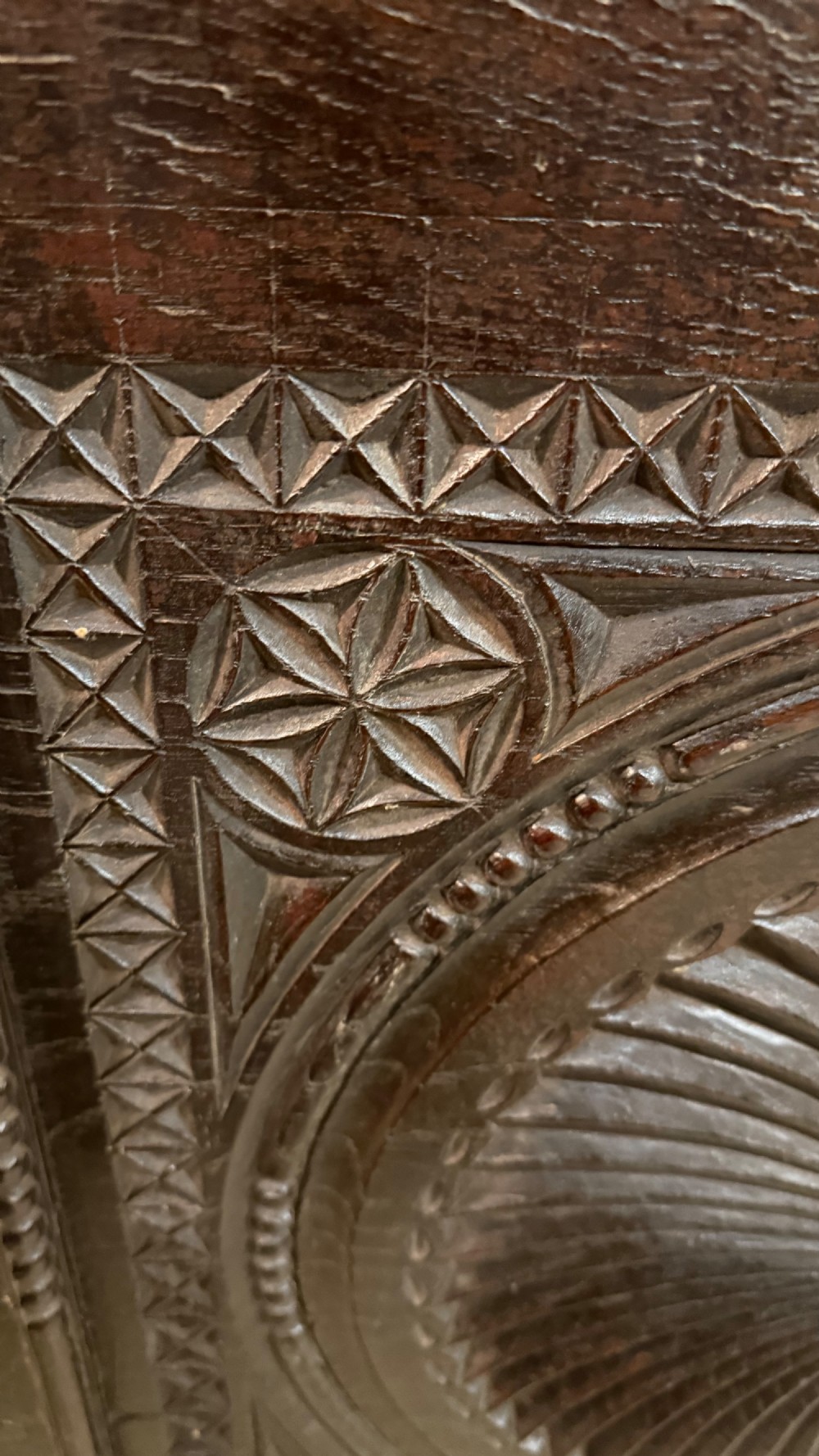 A 16th-century carved dark oak coffer front panel featuring central cross and circular pinwheel motifs with geometric borders. View VIII