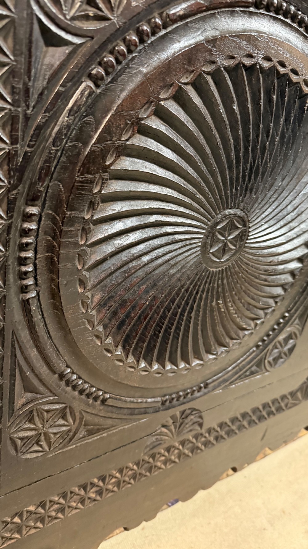A 16th-century carved dark oak coffer front panel featuring central cross and circular pinwheel motifs with geometric borders. View IX