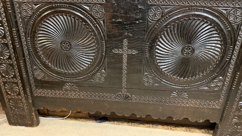 A 16th-century carved dark oak coffer front panel featuring central cross and circular pinwheel motifs with geometric borders. View XI