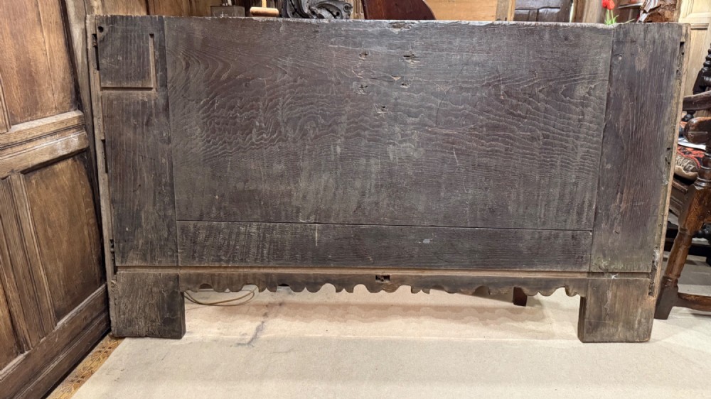 A 16th-century carved dark oak coffer front panel featuring central cross and circular pinwheel motifs with geometric borders. View XIII