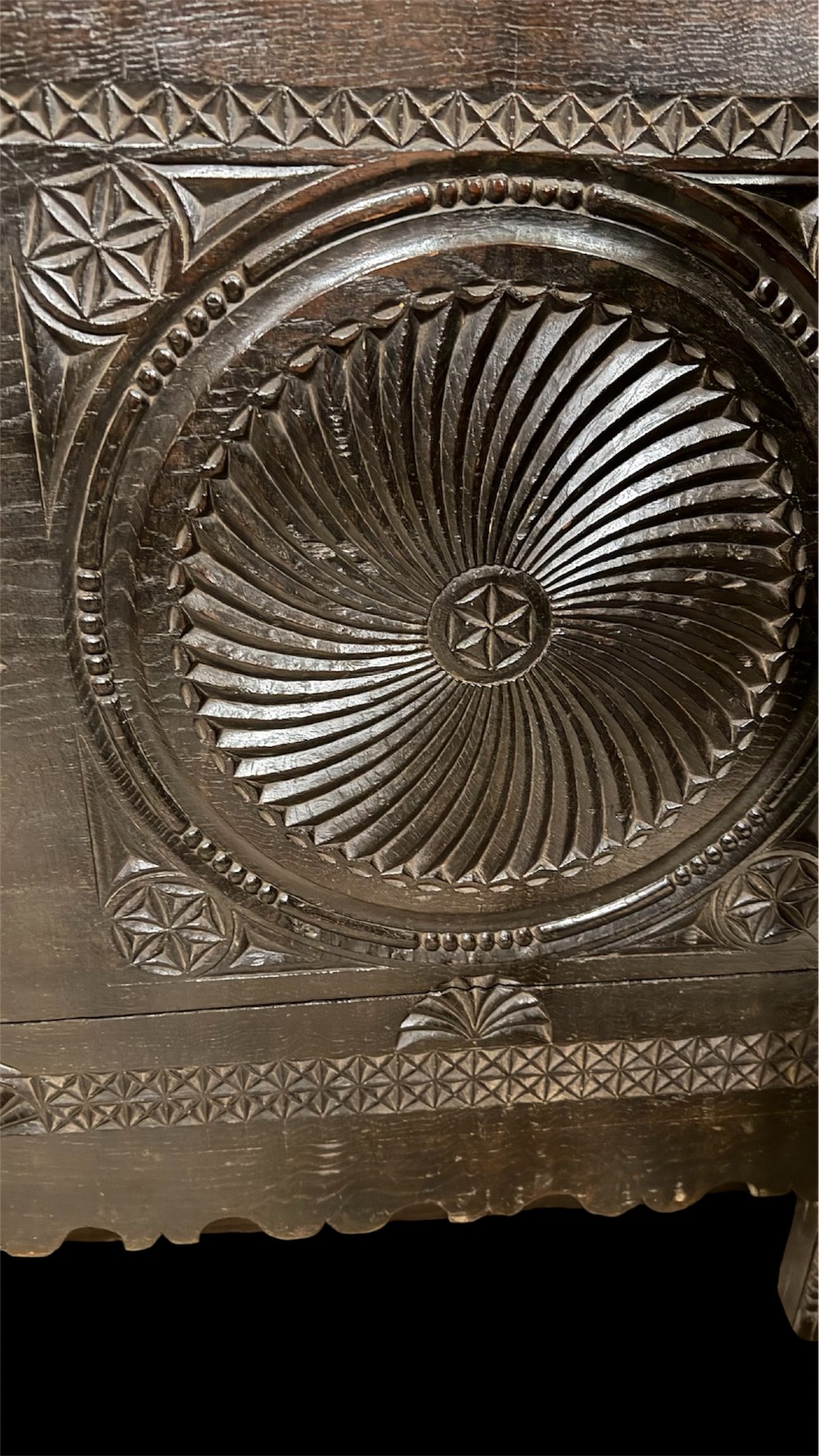 A 16th-century carved dark oak coffer front panel featuring central cross and circular pinwheel motifs with geometric borders. View XIV