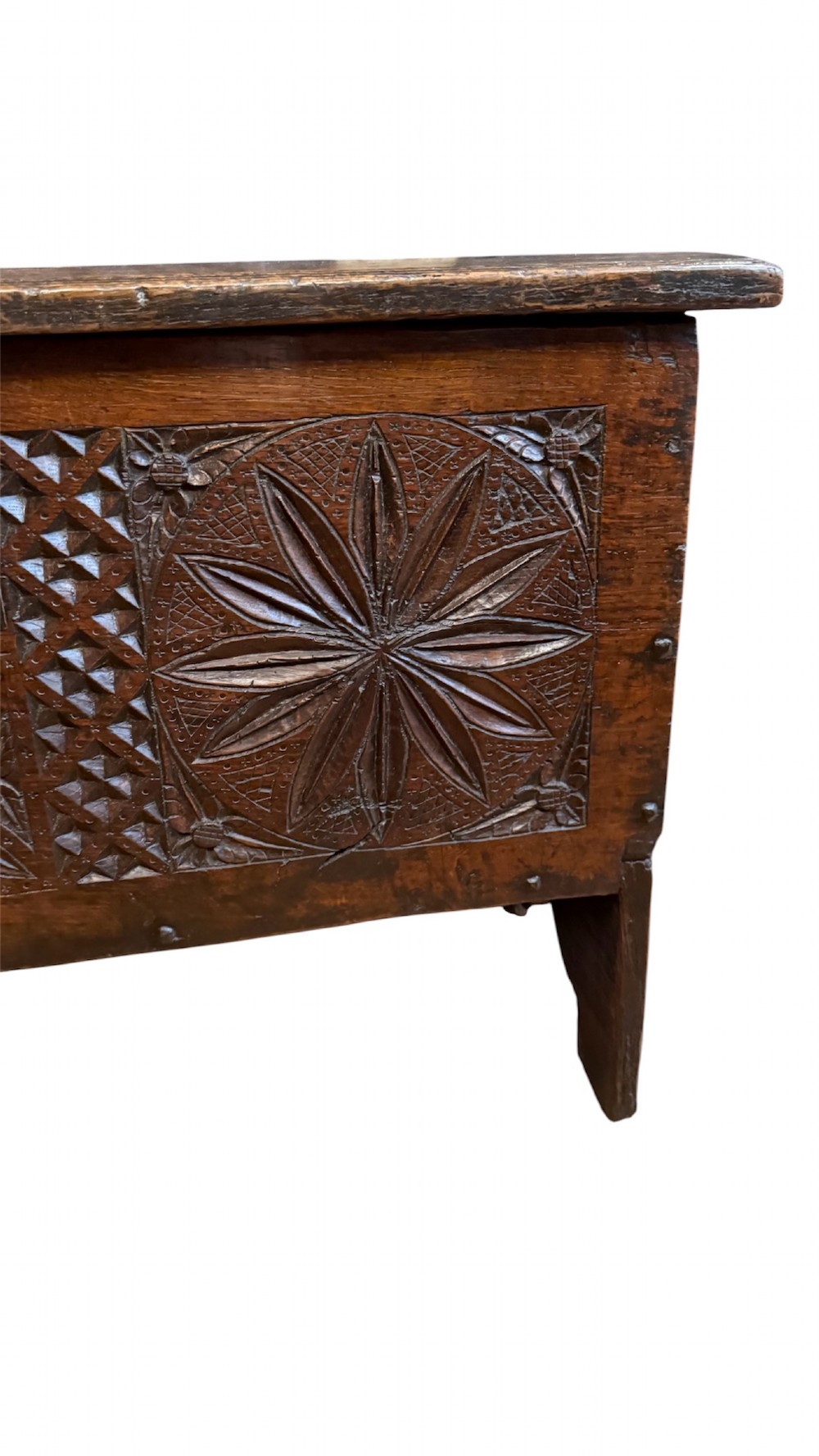 A 16th-century dark oak plank coffer featuring deeply carved floral rosette panels, geometric chip carving, and a central iron lock plate. View IV