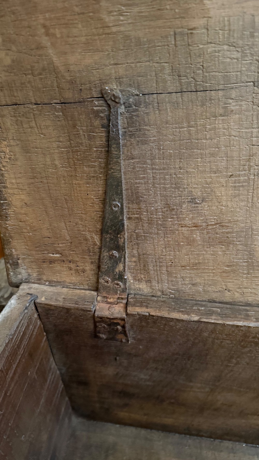 A 16th-century dark oak plank coffer featuring deeply carved floral rosette panels, geometric chip carving, and a central iron lock plate. View X