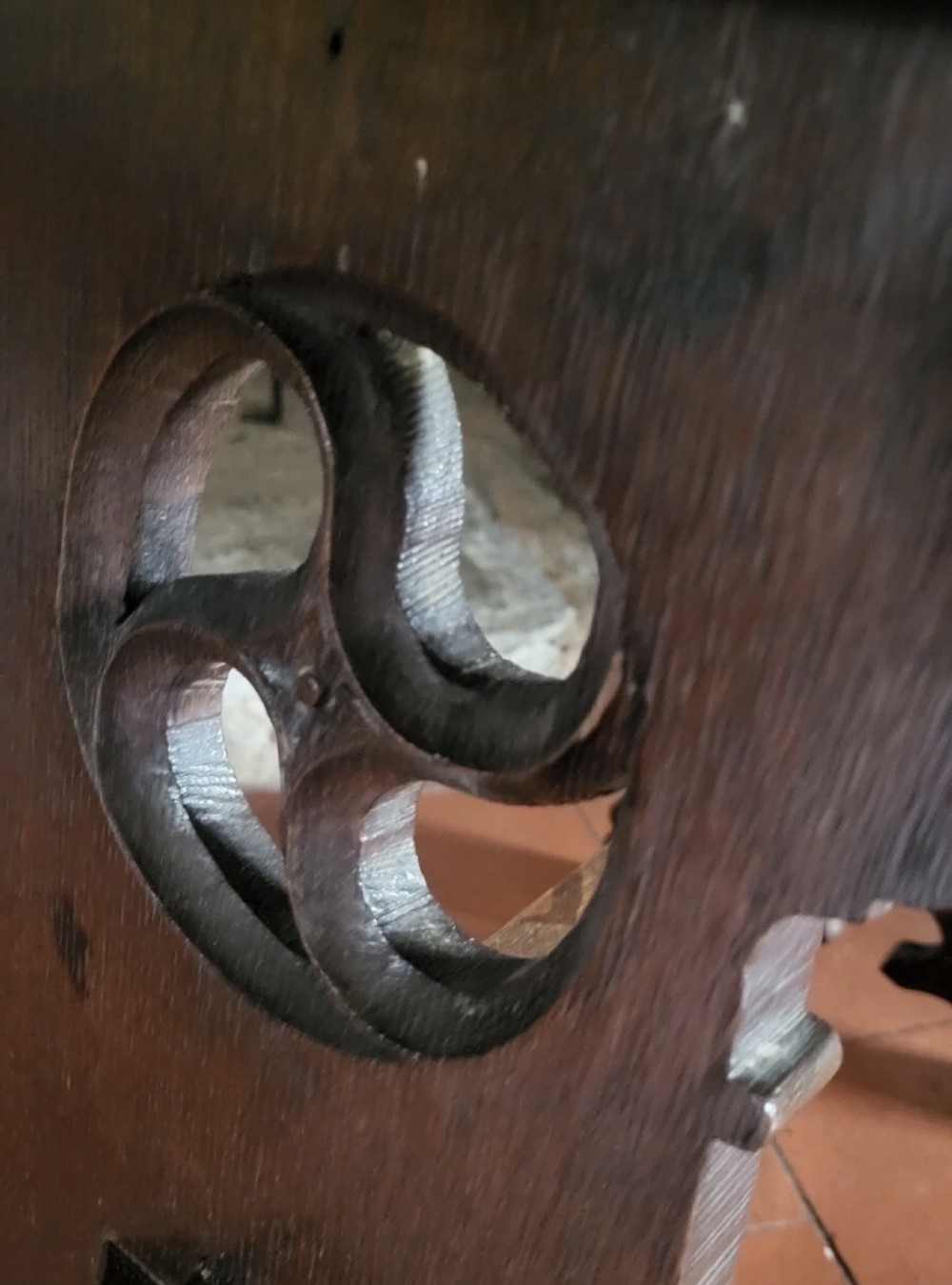A 19th-century dark oak Gothic Revival stool featuring carved tracery cut-outs on the slab legs, a carved central stretcher, and a carved recessed motif on the top. View XI