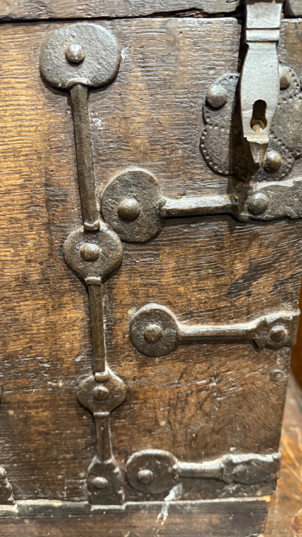 A sixteenth-century rectangular dark wood casket bound with riveted iron straps, featuring a top carrying handle and arched timber base. View III