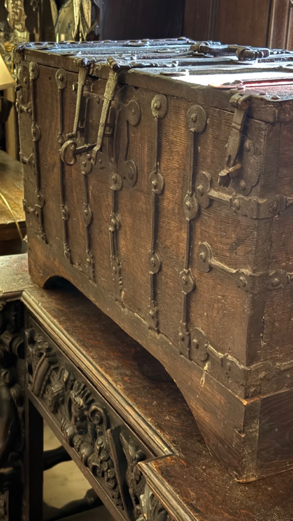 A sixteenth-century rectangular dark wood casket bound with riveted iron straps, featuring a top carrying handle and arched timber base. View IV