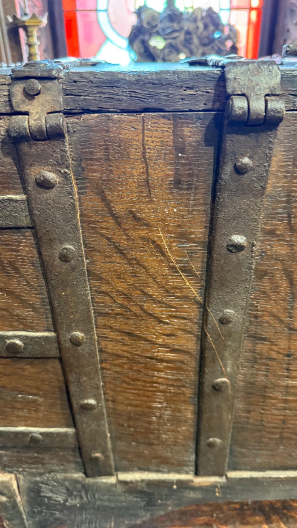 A sixteenth-century rectangular dark wood casket bound with riveted iron straps, featuring a top carrying handle and arched timber base. View X