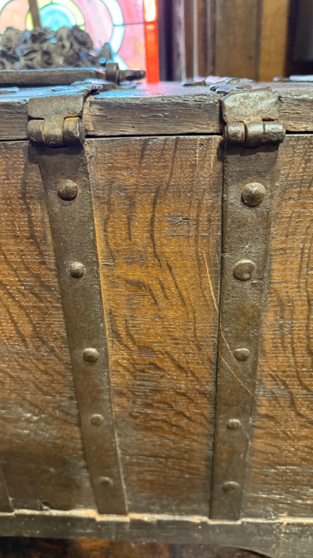 A sixteenth-century rectangular dark wood casket bound with riveted iron straps, featuring a top carrying handle and arched timber base. View XI