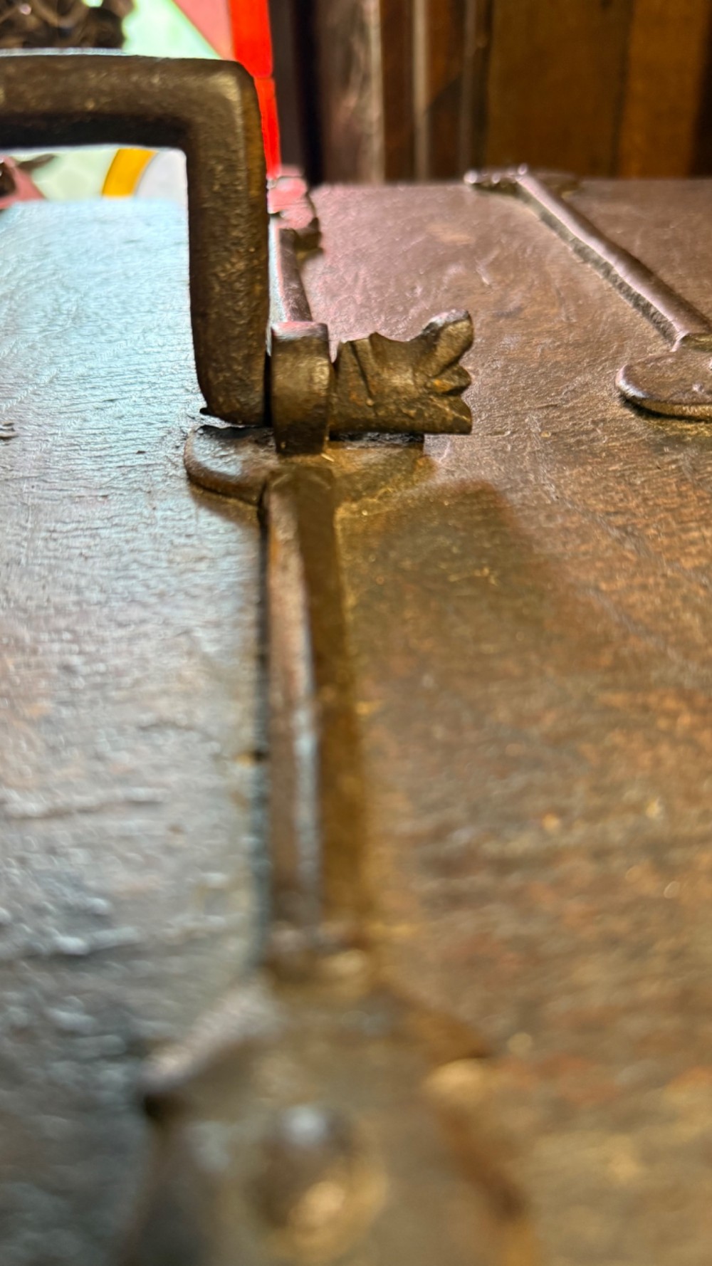 A sixteenth-century rectangular dark wood casket bound with riveted iron straps, featuring a top carrying handle and arched timber base. View XII