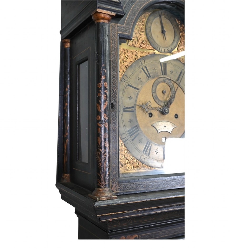 An 18th-century black japanned longcase clock decorated with gold chinoiserie scenes and featuring an arched brass dial. View V