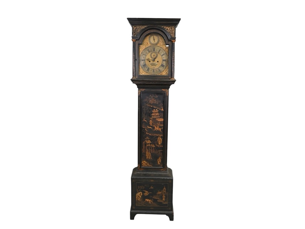 An 18th-century black japanned longcase clock decorated with gold chinoiserie scenes and featuring an arched brass dial.