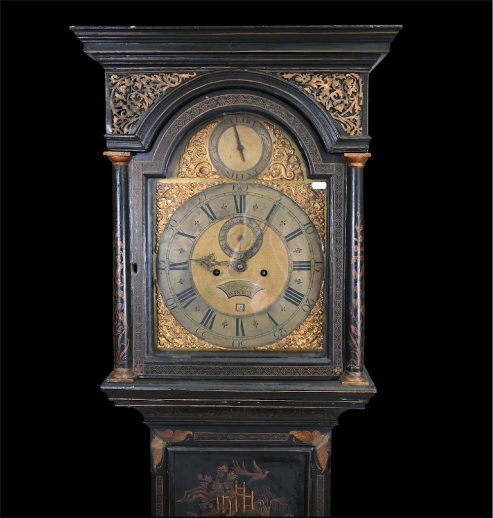 An 18th-century black japanned longcase clock decorated with gold chinoiserie scenes and featuring an arched brass dial. View XII