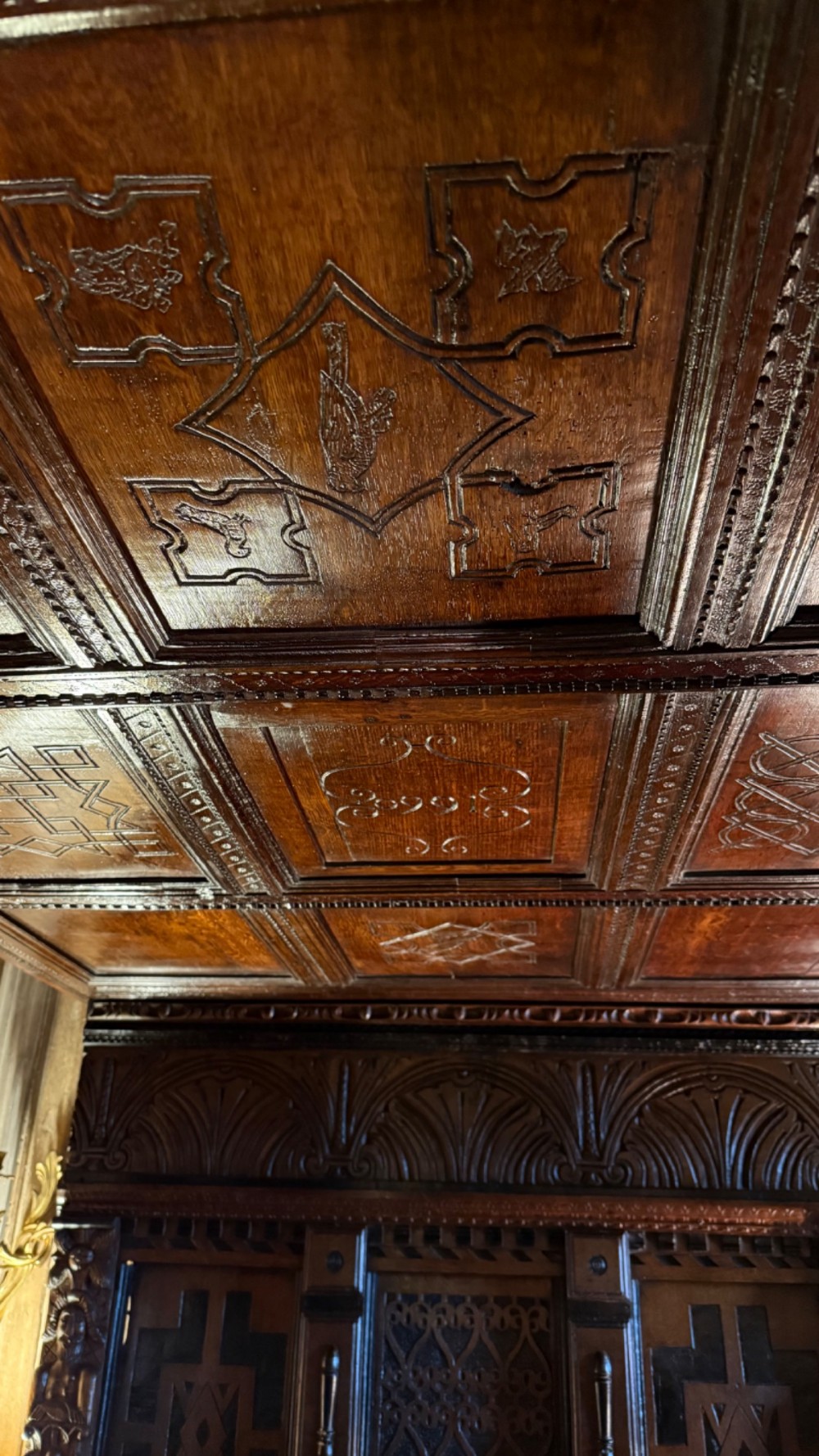A 17th-century English oak tester bed featuring a heavy panelled canopy, carved geometric headboard, and turned wooden posts. View V