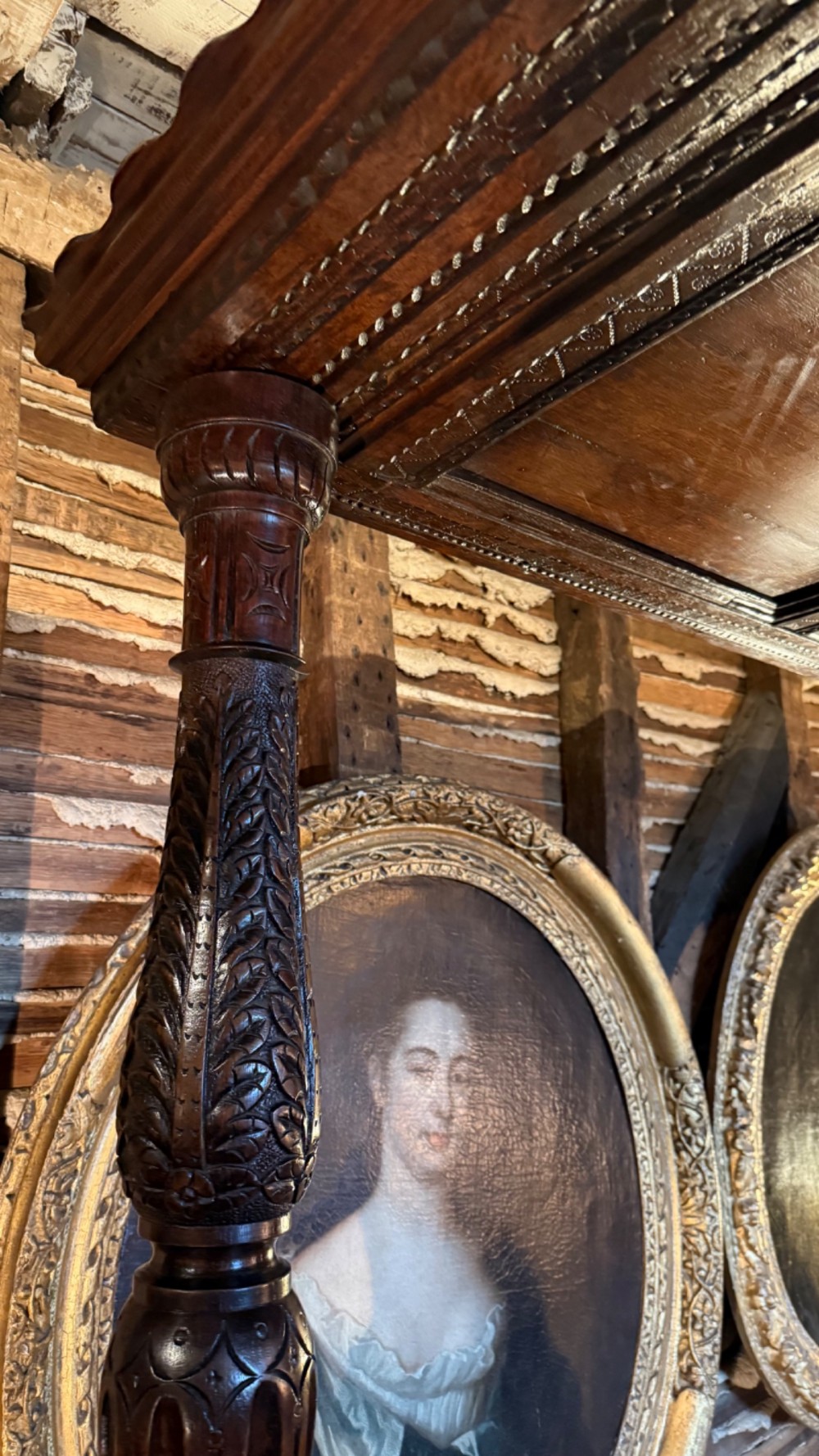 A 17th-century English oak tester bed featuring a heavy panelled canopy, carved geometric headboard, and turned wooden posts. View VI
