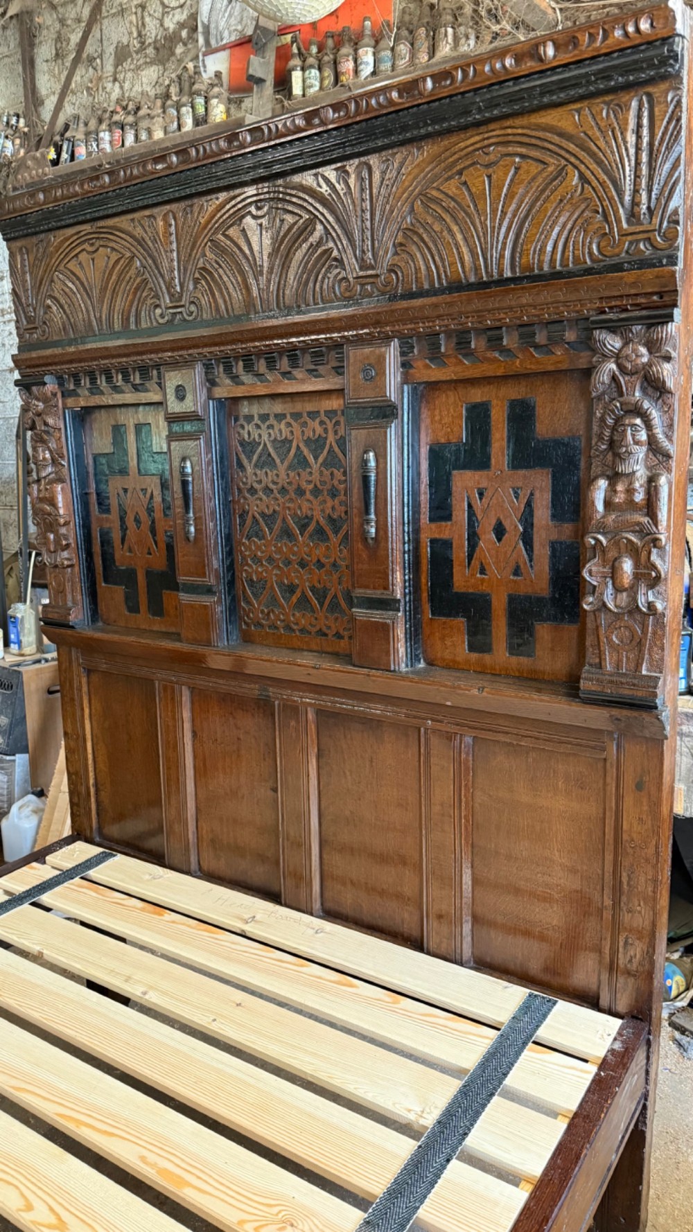 A 17th-century English oak tester bed featuring a heavy panelled canopy, carved geometric headboard, and turned wooden posts. View X