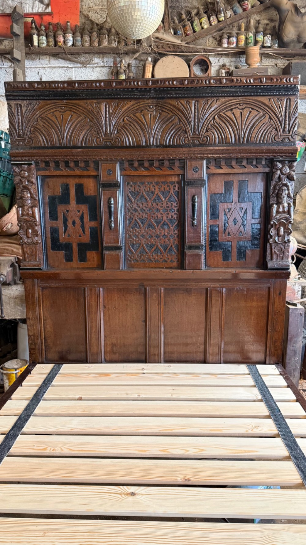 A 17th-century English oak tester bed featuring a heavy panelled canopy, carved geometric headboard, and turned wooden posts. View XI