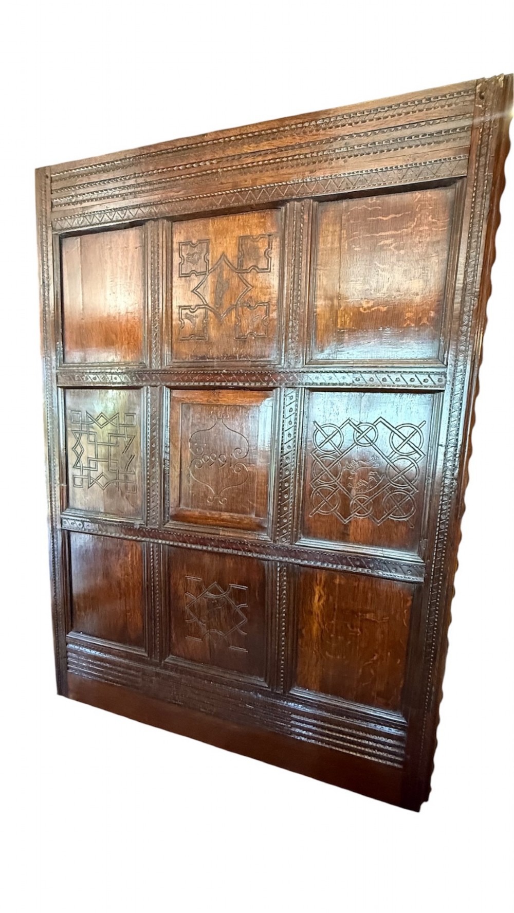 A 17th-century English oak tester bed featuring a heavy panelled canopy, carved geometric headboard, and turned wooden posts. View XIV