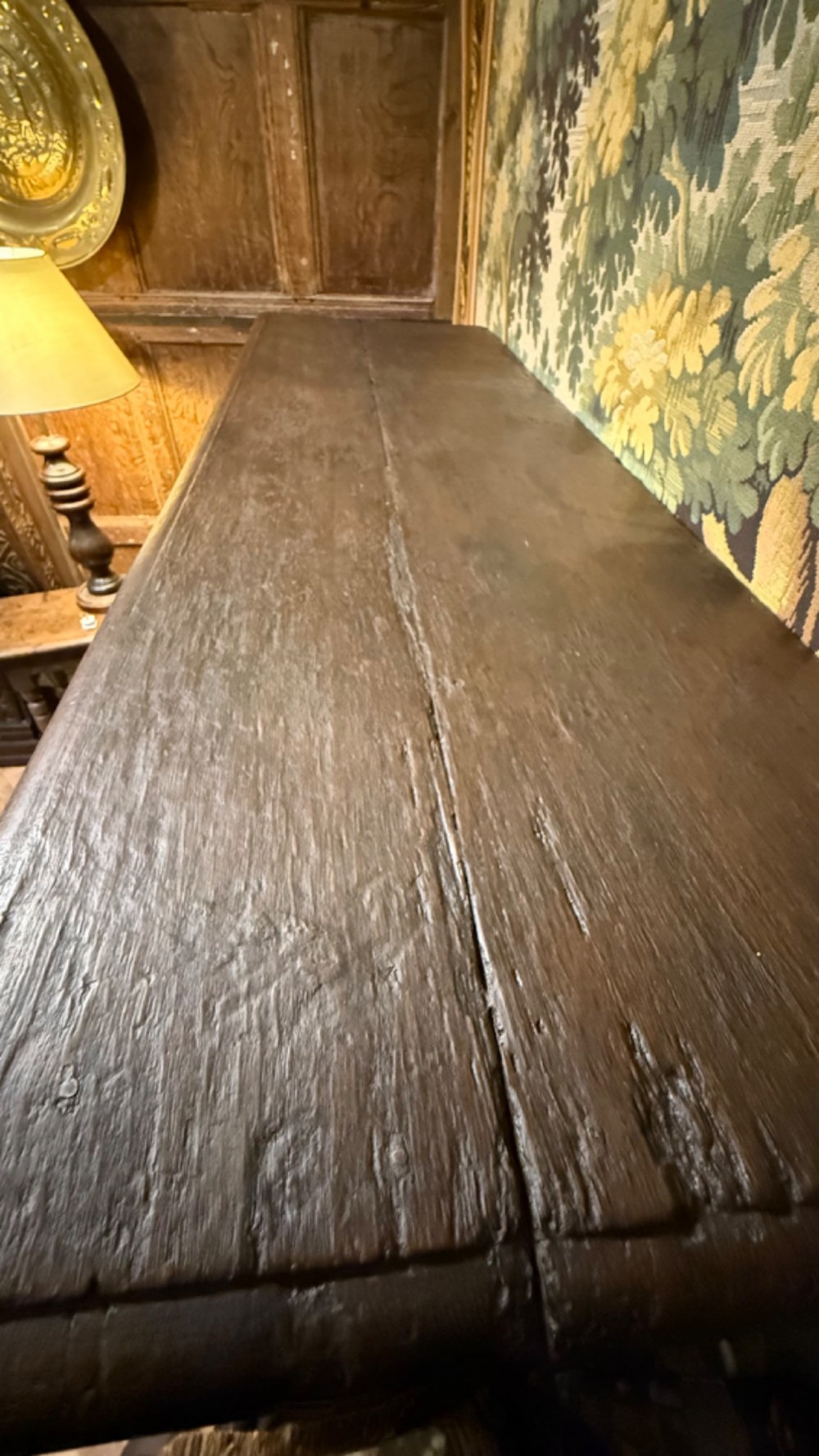 A 17th-century style dark carved oak livery cupboard featuring ornate relief carving, a central face motif panel, turned supports, and an open lower shelf. View XIV