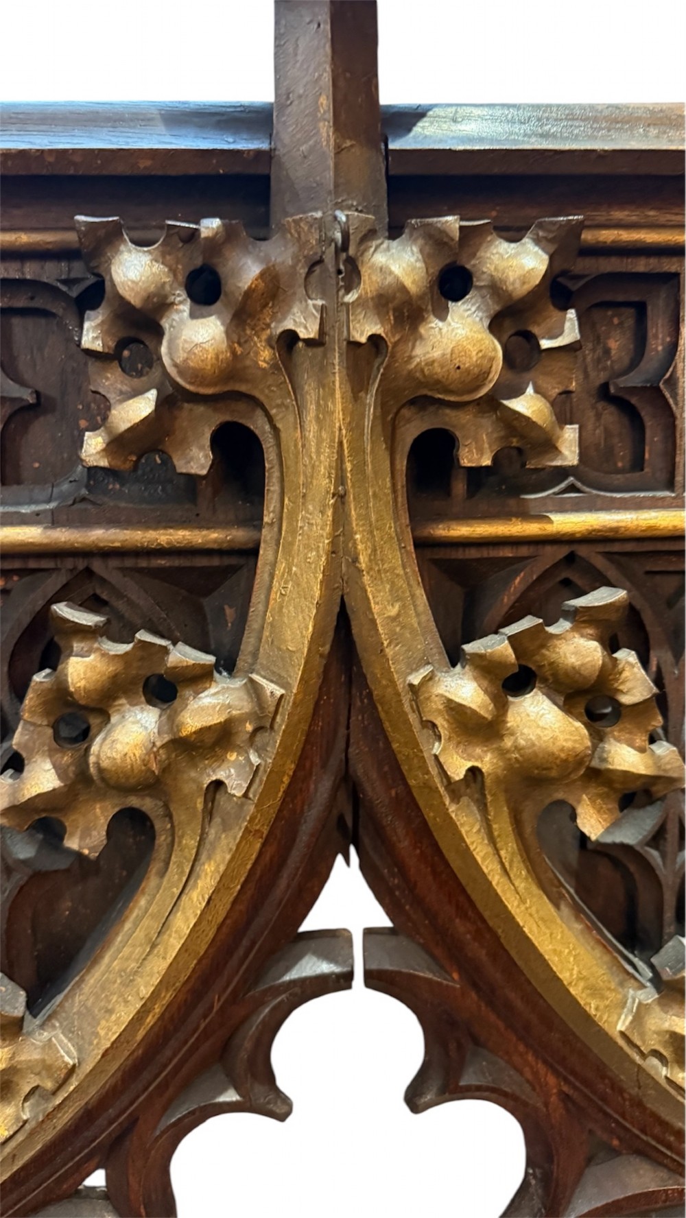 A dark carved oak Gothic Revival mirror frame featuring a pointed arch, intricate tracery, gilded crockets, and decorative finials. View V