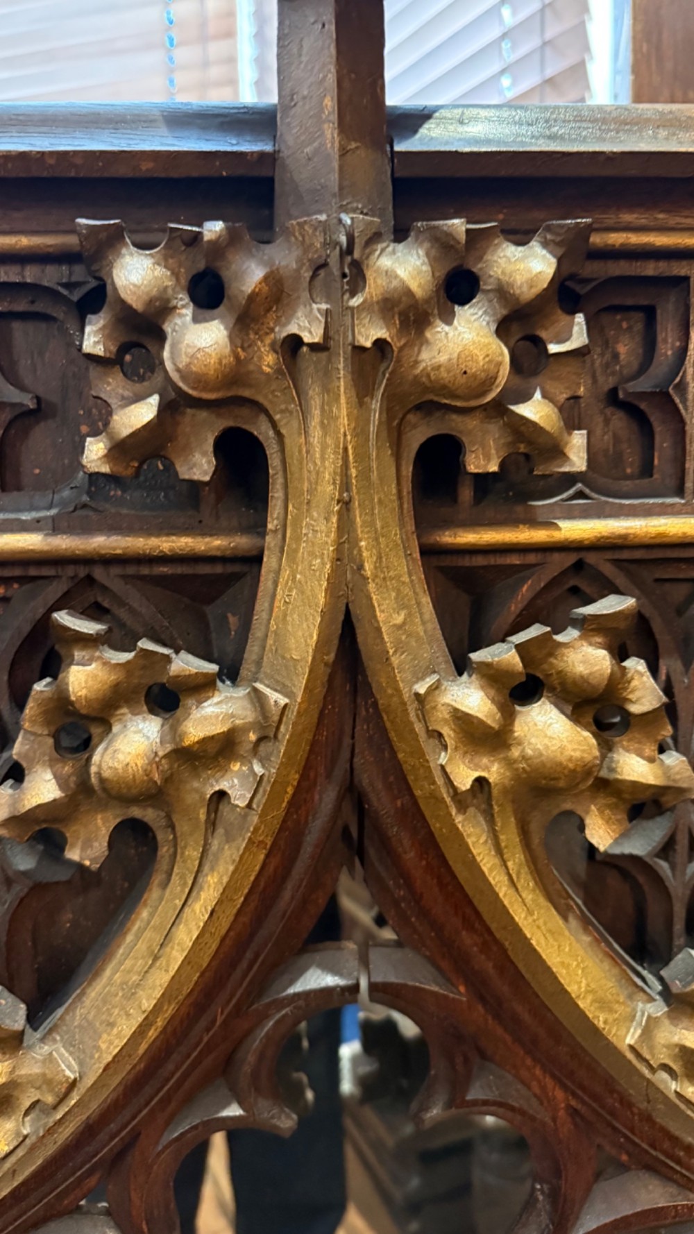 A dark carved oak Gothic Revival mirror frame featuring a pointed arch, intricate tracery, gilded crockets, and decorative finials. View X