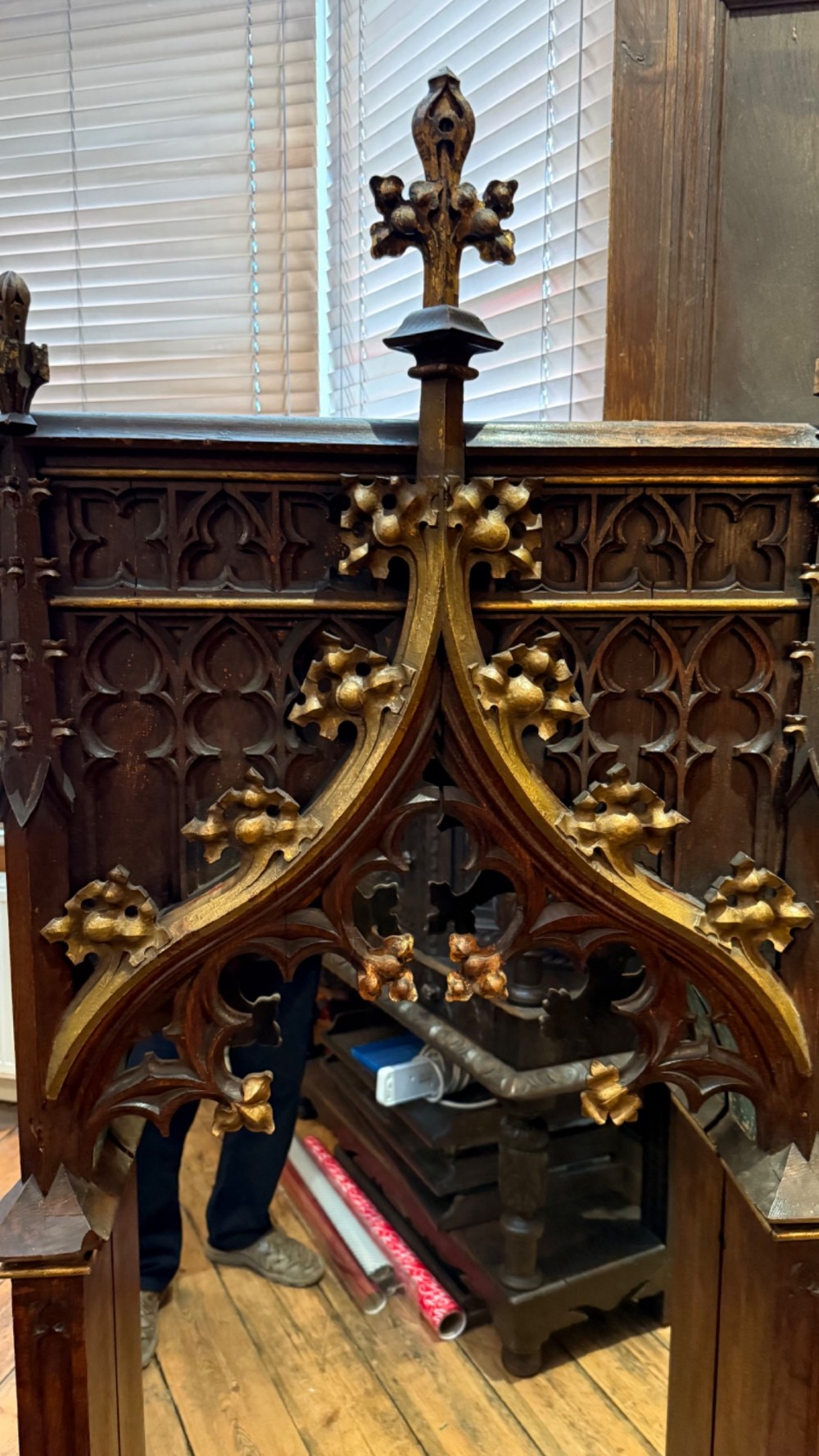 A dark carved oak Gothic Revival mirror frame featuring a pointed arch, intricate tracery, gilded crockets, and decorative finials. View XI